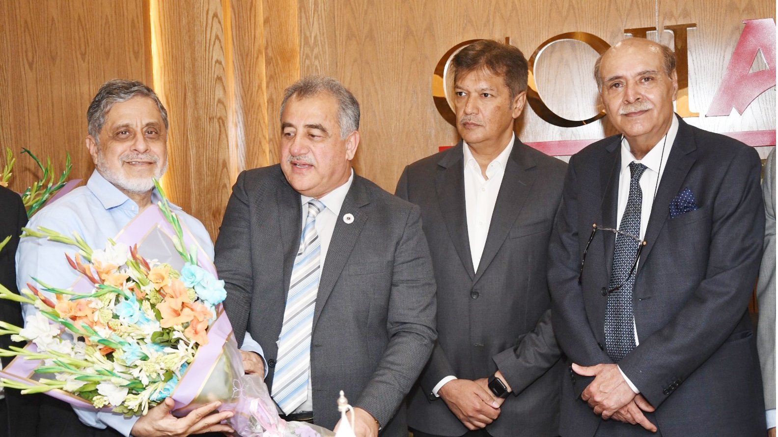 Secretary General Hanif Gohar presenting flowers to President of UBG Zubair Tufail.