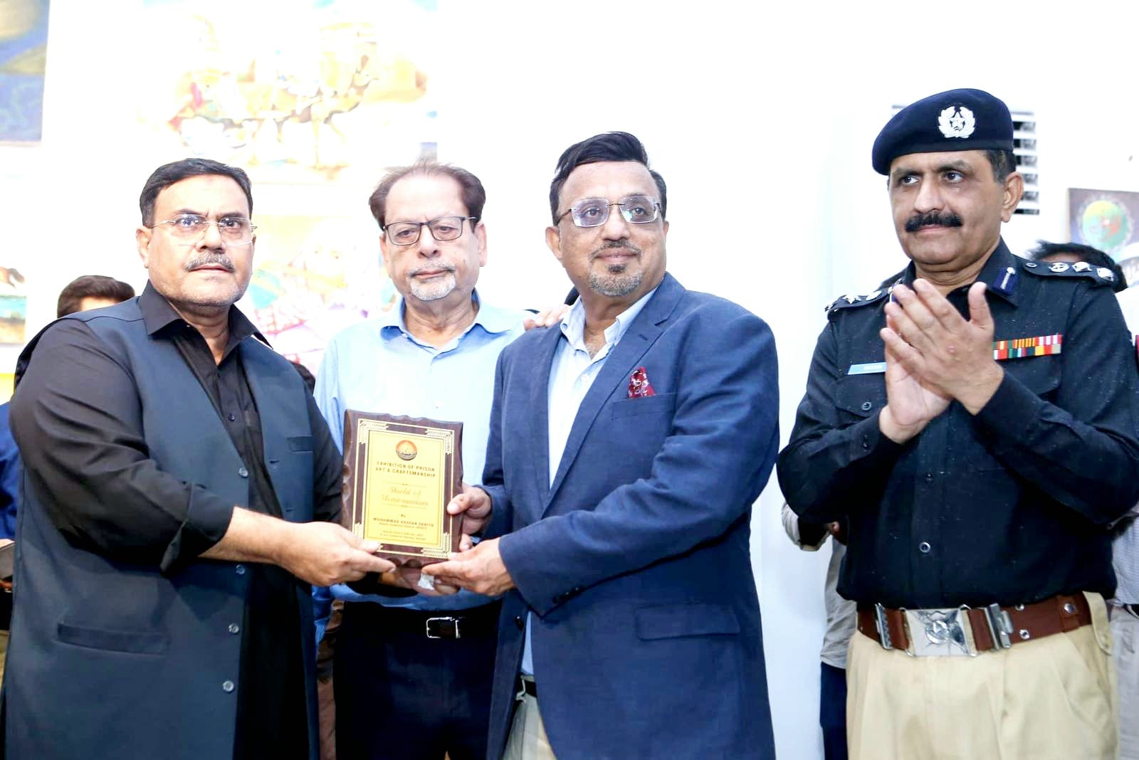 IG Prison presents a commemorative shield to Saleem Kassim Patel for his cooperation in organising the exhibition.