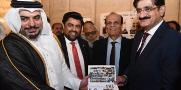 Nayef Shahein R. M. Al-Sulaiti, Consul General of Qatar, presents a stamp folder from Arif Balgamwala