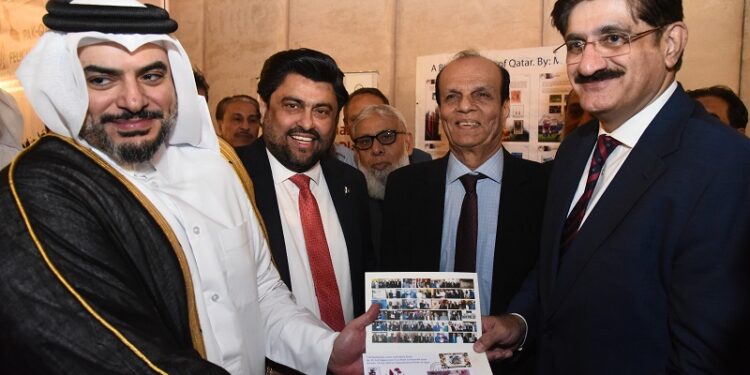 Nayef Shahein R. M. Al-Sulaiti, Consul General of Qatar, presents a stamp folder from Arif Balgamwala