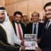Nayef Shahein R. M. Al-Sulaiti, Consul General of Qatar, presents a stamp folder from Arif Balgamwala