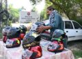 A local vendor is displaying motorcycle helmet on his cart to attract the customers at DPO office Chowk.