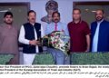 Zahid Iqbal Chaudhry, presents flowers to Ikram Rajput,