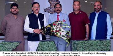 Zahid Iqbal Chaudhry, presents flowers to Ikram Rajput,