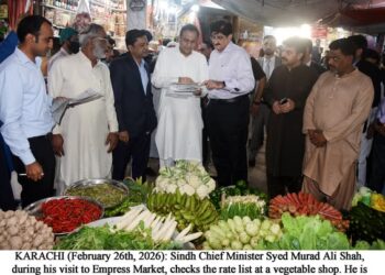 Syed Murad Ali Shah, during his visit to Empress Market, checks the rate list at a vegetable shop.
