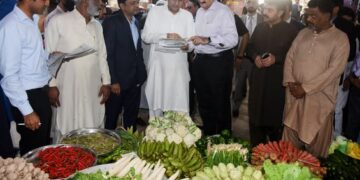 Syed Murad Ali Shah, during his visit to Empress Market, checks the rate list at a vegetable shop.