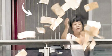 Wife throws banknotes out of window after quarreling with husband.