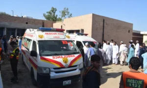 Security forces and rescue teams at the scene of twin vehicle explosions in Bannu