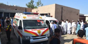 Security forces and rescue teams at the scene of twin vehicle explosions in Bannu