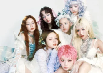 XG girl group performing in neon outfits with synchronized choreography on stage