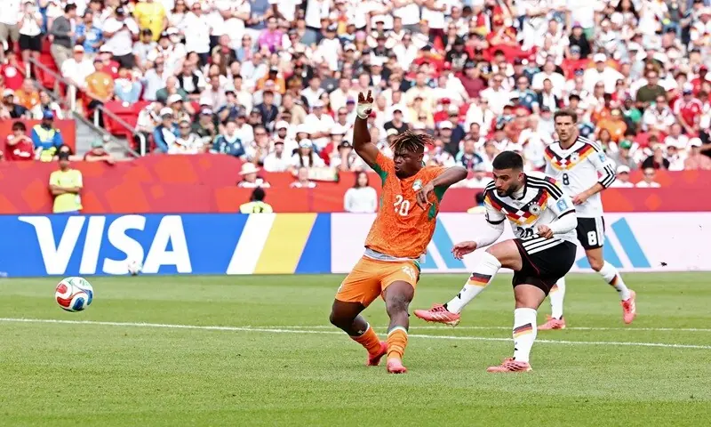 Germany players celebrating a late goal against Ivory Coast in World Cup match.
