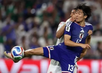 Japan football players celebrating goals against Tunisia in World Cup Group F match.