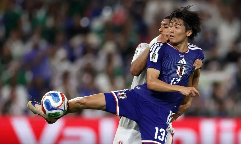 Japan football players celebrating goals against Tunisia in World Cup Group F match.