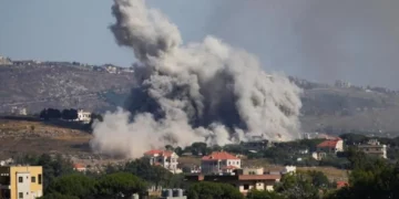 Aerial view of damaged buildings and smoke in southern Lebanon amid Israel Hezbollah ceasefire claims and ongoing strikes.