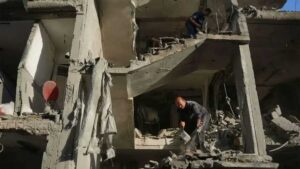 Damaged buildings in Gaza after Israeli airstrikes with emergency responders at the scene.