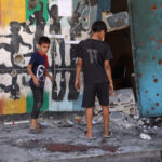 Destroyed buildings in Gaza with displaced families and children amid conflict aftermath