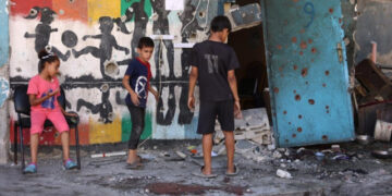 Destroyed buildings in Gaza with displaced families and children amid conflict aftermath