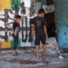 Destroyed buildings in Gaza with displaced families and children amid conflict aftermath