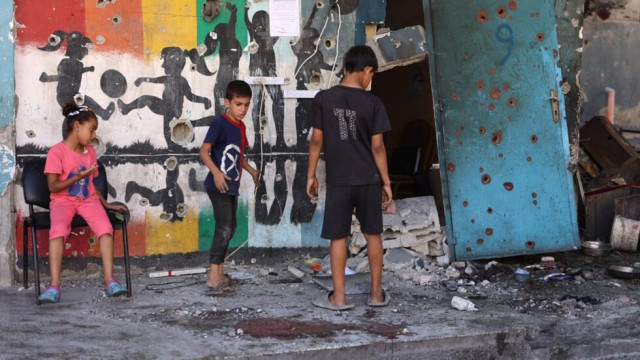 Destroyed buildings in Gaza with displaced families and children amid conflict aftermath