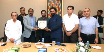Officials of Pakistan Tanners Association and Sindh government exchange crests during an industry meeting in Karachi.