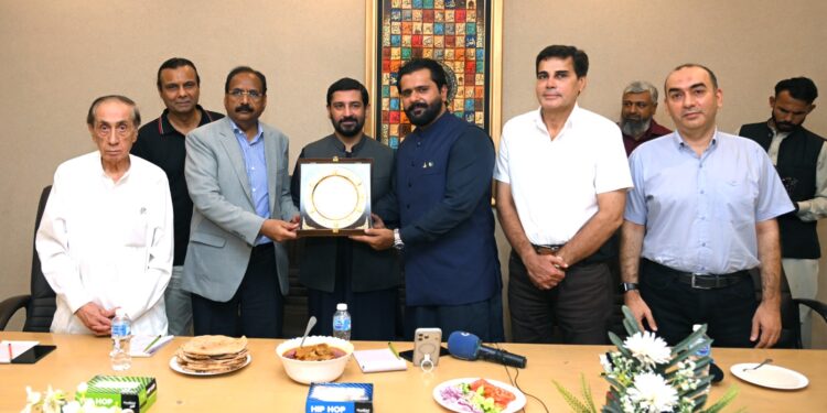 Officials of Pakistan Tanners Association and Sindh government exchange crests during an industry meeting in Karachi.