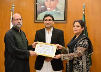 Senior Pakistani artist Aliya Faizi receiving a Certificate of Appreciation at the FPCCI Lifestyle Committee exhibition alongside organisers and guests.