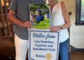 Outgoing and incoming Rotary Club presidents reading the latest issue of Rotary Magazine.