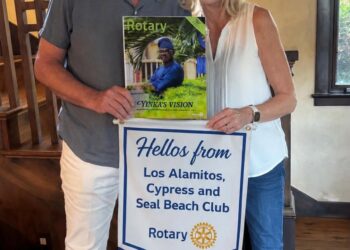 Outgoing and incoming Rotary Club presidents reading the latest issue of Rotary Magazine.