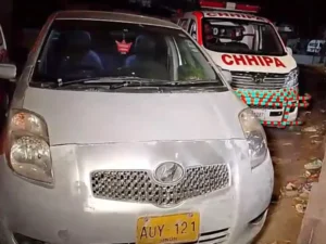 Police officers collecting evidence after a fatal shooting outside a residence in Orangi Town Karachi.