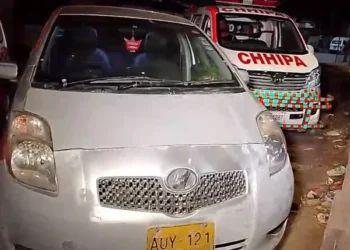 Police officers collecting evidence after a fatal shooting outside a residence in Orangi Town Karachi.