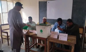 Voters queue outside a polling station during the first phase of the Azad Jammu and Kashmir elections in Mirpur division.