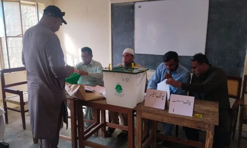 Voters queue outside a polling station during the first phase of the Azad Jammu and Kashmir elections in Mirpur division.