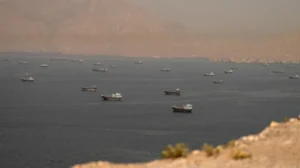 Military activity and commercial shipping in the Strait of Hormuz following US strikes on Iranian targets.