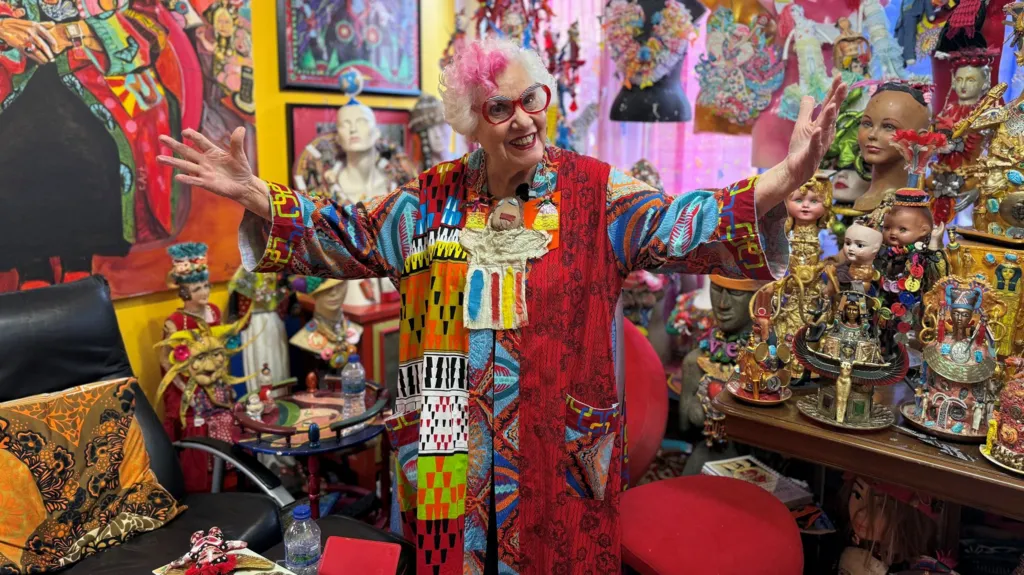 Artist Sue Kreitzman poses inside her vibrant Mile End home, which she transformed into a living art installation.