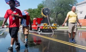 People cool off at the Great American State Fair on the National Mall during an extreme heat wave in Washington, DC.