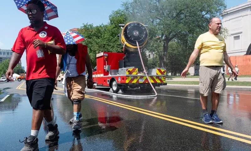 People cool off at the Great American State Fair on the National Mall during an extreme heat wave in Washington, DC.