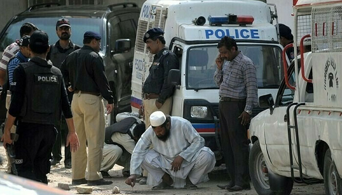 Police secure the area outside a bank in Clifton, Karachi, where a young doctor was killed during an armed robbery.