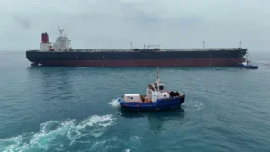 Oil tanker sailing through the Strait of Hormuz as geopolitical tensions push crude prices higher.