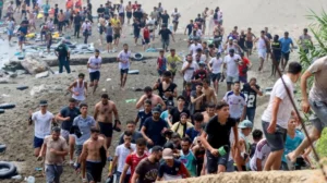 Thousands of migrants cross into Spain's North African enclave of Ceuta from Morocco amid a major migration surge.