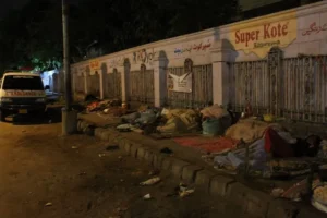 Police inspect the site where a pickup truck struck a homeless man and injured his son in DHA Karachi.