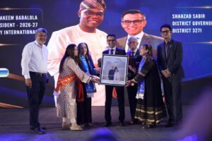 District Governor Shahzad Sabir receives a framed commemorative photograph from Rotary Club of Karachi Capital Hills members during a ceremonial presentation.