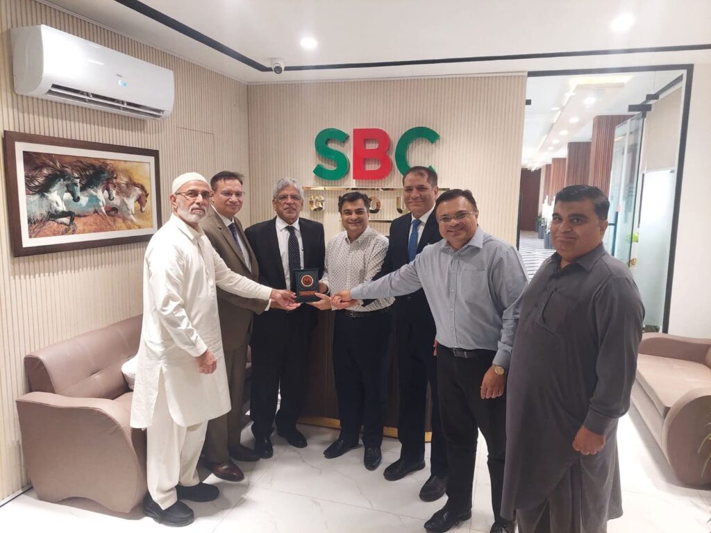 Aun Ali Supariwala receiving a commemorative shield from SBC Group of Companies during a business luncheon meeting.