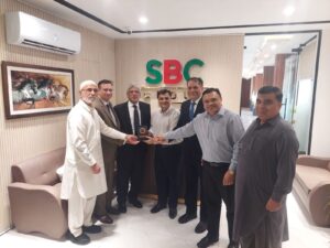 Aun Ali Supariwala receiving a commemorative shield from SBC Group of Companies during a business luncheon meeting.