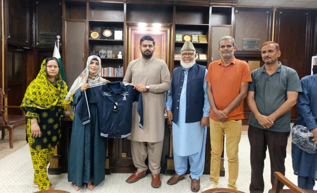 Deputy Commissioner Nadir Shehzad Khan presents sports kits to coaches and players during the Sindh Basketball Association's girls' coaching camp in Sukkur.