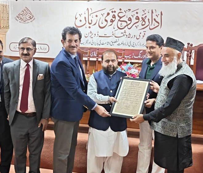 Federal Minister Aurangzeb Khan Khichi presents a certificate to Haji Muhammad Rafiq Pardesi during the launch ceremony of the historic 22-volume Urdu Dictionary in Islamabad.