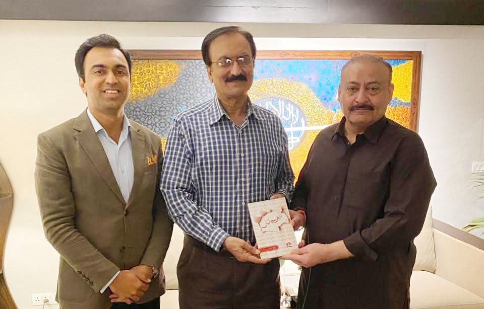 MNA Abdul Qadir Patel receives a book from author Rafiq Ahmed Memon as Ammar Rafiq looks on.