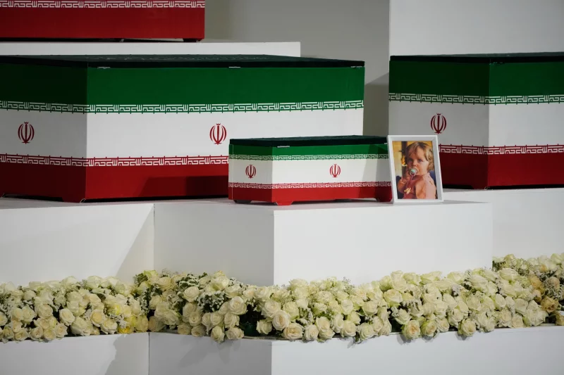 Iranian officials and mourners pay tribute beside Ayatollah Ali Khamenei's coffin in Tehran.