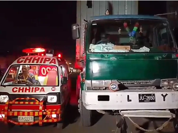 Police and rescue workers at the site of a trailer accident in Karachi's Mauripur area that killed a teenage motorcyclist.