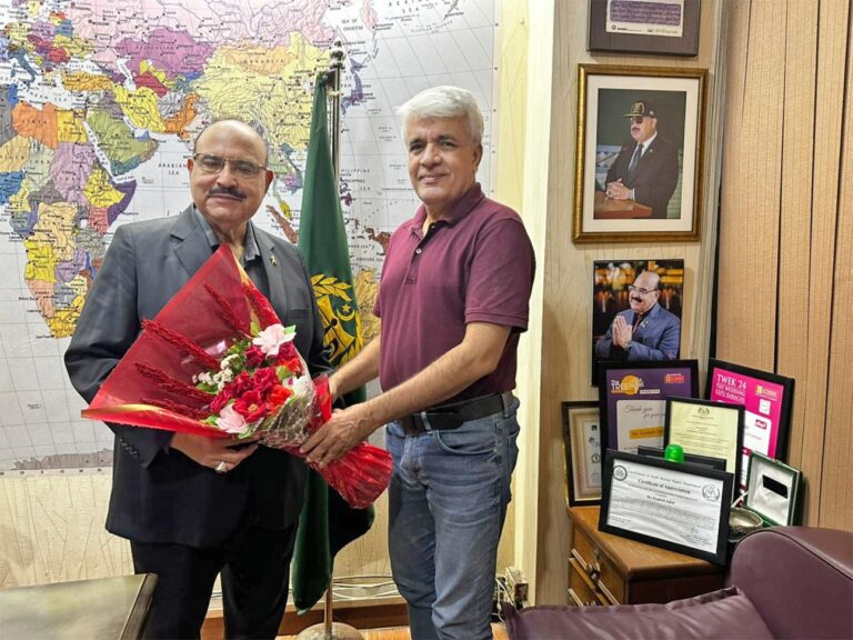 Syed Turab Shah presents flowers to Kaukab Iqbal after his return from Umrah.