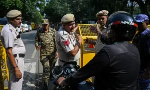 Protesters climb over barricades at Jantar Mantar in New Delhi before police detain Cockroach Janta Party leaders